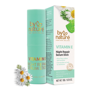 By Nature Vitamin E Night Repair Serum Stick packaging with chamomile flowers on a white background