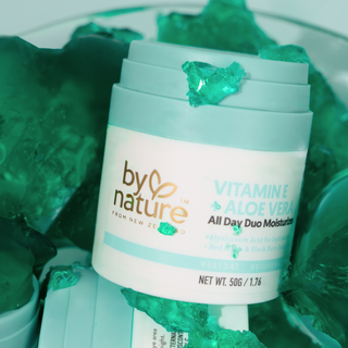 By Nature Vitamin E All Day Moisturizer product with green jelly in the background
