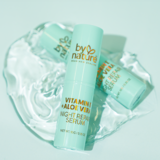 Two bottles of 'by nature' Vitamin E Aloe Vera Night Repair Serum on a light blue background